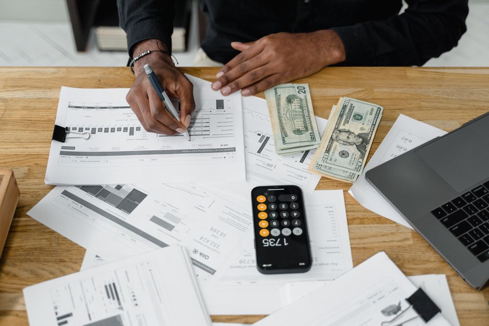 Financial reports, cash and a calculator on a desk
