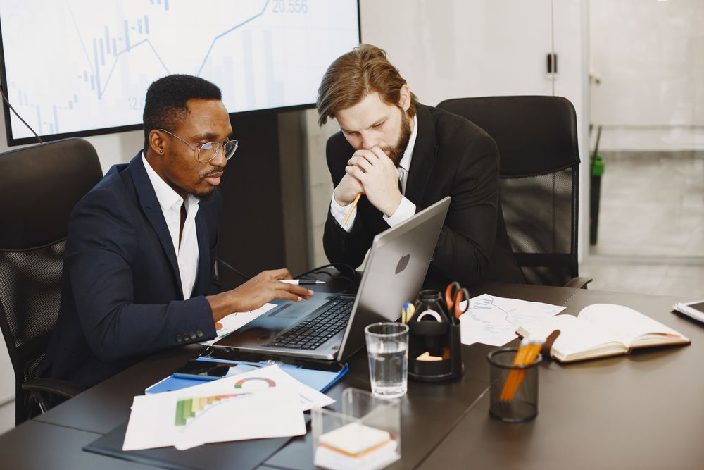 Two colleagues reviewing financials on a laptop